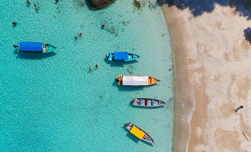 boats in blue water near beach