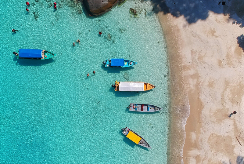 boats in blue water near beach